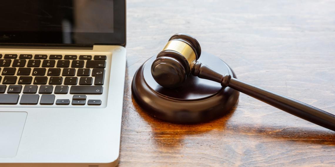 A judge's gavel sits beside a computer screen